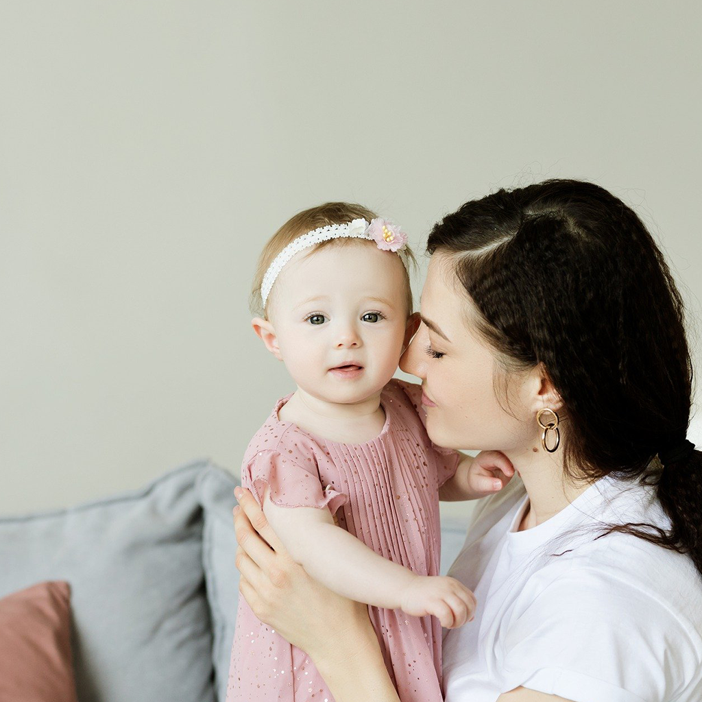 a woman smiling and holding a small child